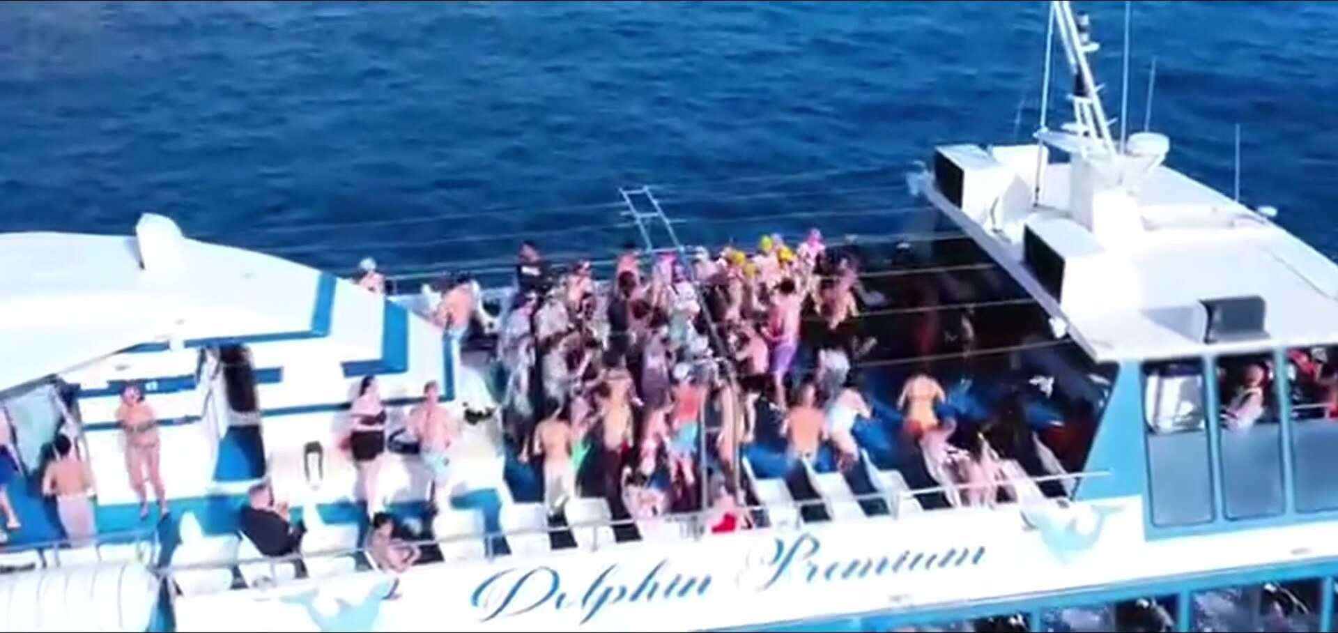 Cubierta del catamarán de fiesta llena de gente bailando durante la travesía