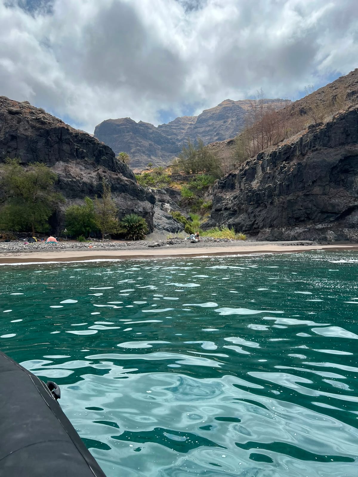 Strand aan de voet van een groene kloof aan de westkust van Gran Canaria